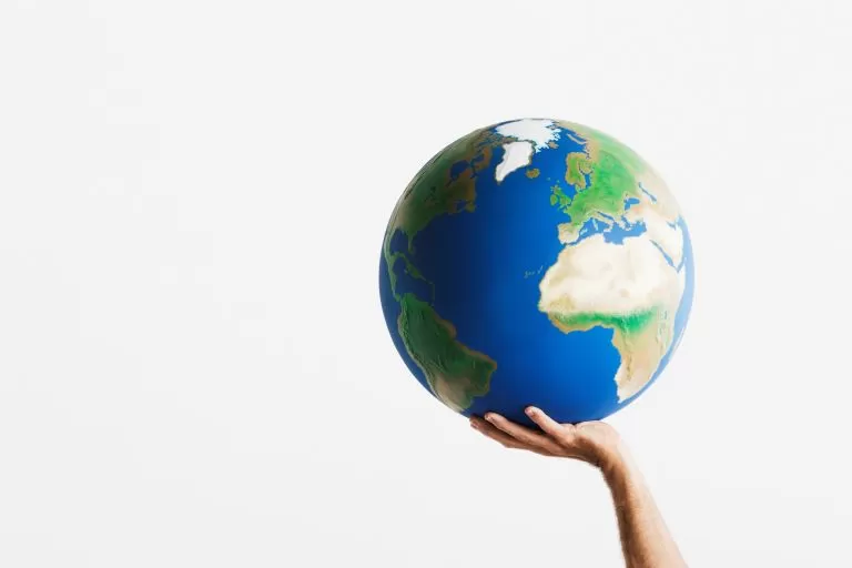 hand holding up globe of the world